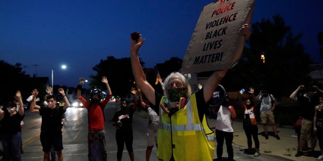 People gather to protest Wednesday, Aug. 26, 2020, in Kenosha, Wis. (AP Photo/Morry Gash)