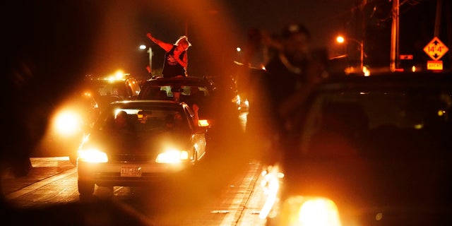 A person in a car raises her fist in solidarity with a march protesting the Sunday police shooting of Jacob Blake, in Kenosha, Wis., on Wednesday. (AP Photo/David Goldman)