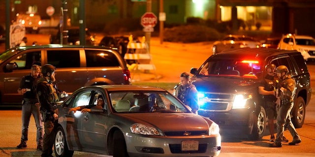 Police stop a car near where protesters gather for a fourth night to demonstrate against the police shooting of Jacob Blake in Kenosha, Wis., late Wednesday. (AP Photo/David Goldman)