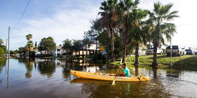 Martin Almanza paddles a canoe through some street flooding following landfall of Hurricane Laura on Aug. 27, in Galveston, Texas. (Brett Coomer/Houston Chronicle via AP)