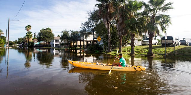 Martin Almanza paddles a canoe through some street flooding following landfall of Hurricane Laura on Aug. 27, in Galveston, Texas. (Brett Coomer/Houston Chronicle via AP)