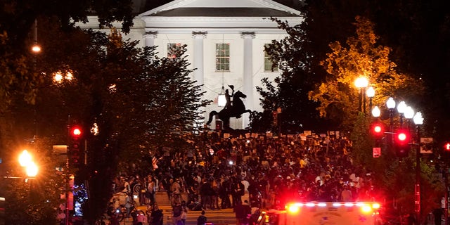 Protestors rally along 16th Street, Northwest, renamed Black Lives Matter Plaza, Thursday, Aug. 27, 2020, in Washington, with the White House in view. President Donald Trump is set to deliver his acceptance speech later Thursday night from the nearby White House South Lawn. (AP Photo/J. Scott Applewhite)