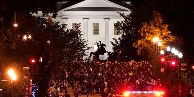 Protestors rally along 16th Street, Northwest, renamed Black Lives Matter Plaza, Thursday, Aug. 27, 2020, in Washington, with the White House in view. President Donald Trump is set to deliver his acceptance speech later Thursday night from the nearby White House South Lawn. (AP Photo/J. Scott Applewhite)