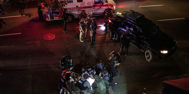 A man is treated by medics after being shot during a confrontation on Saturday, Aug. 29, 2020, in Portland, Ore. He later succumbed to his injuries. (AP Photo/Paula Bronstein)