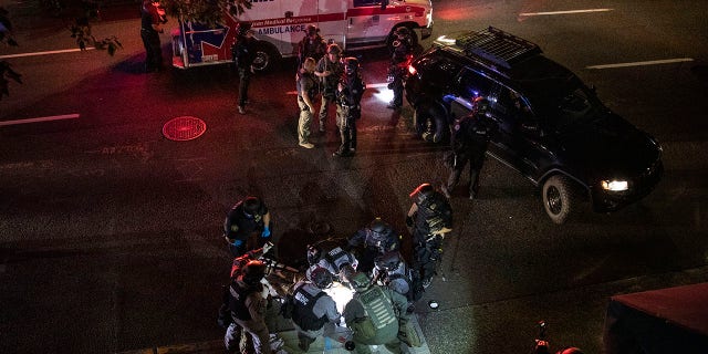 A man is treated by medics after being shot during a confrontation on Saturday, Aug. 29, 2020, in Portland, Ore. He later succumbed to his injuries. (AP Photo/Paula Bronstein)