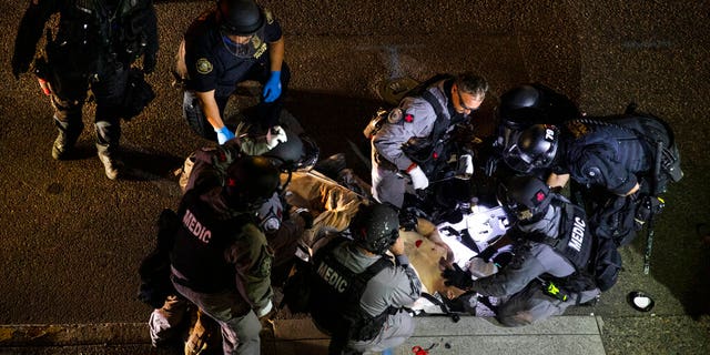 A man is treated after being shot Saturday, Aug. 29, 2020, in Portland, Ore. Victim later succumbed to his injuries (AP Photo/Paula Bronstein)