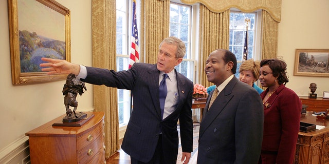 In this Thursday, Feb. 17, 2005, file photo provided by the White House, President Bush, left, and first lady Laura Bush, second right, meet with Paul Rusesabagina, center-right, and his wife, Tatiana, right, in the Oval Office. (Eric Draper/The White House via AP )