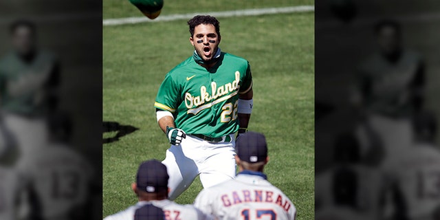 Oakland Athletics' Ramon Laureano (22) charges the Houston Astros dugout after being hit by a pitch thrown by Astros' Humberto Castellanos in the seventh inning of a baseball game Sunday, Aug. 9, 2020, in Oakland, Calif.
