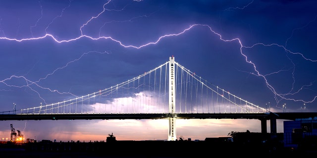 Lightning forks over the San Francisco-Oakland Bay Bridge as a storm passes over Oakland, Calif., Sunday, Aug. 16, 2020. Numerous lightning strikes early Sunday sparked brush fires throughout the region.