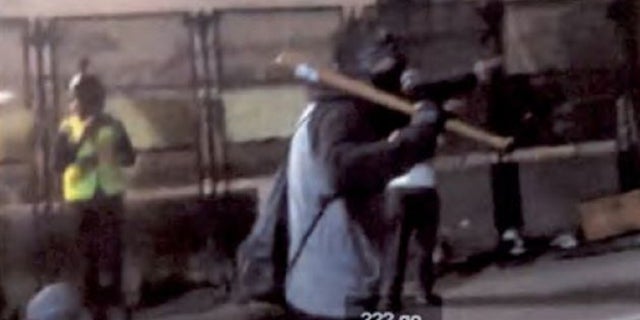 Images capture a bat-wielding suspect accused of striking a federal officer during a July 27 protest in downtown Portland.