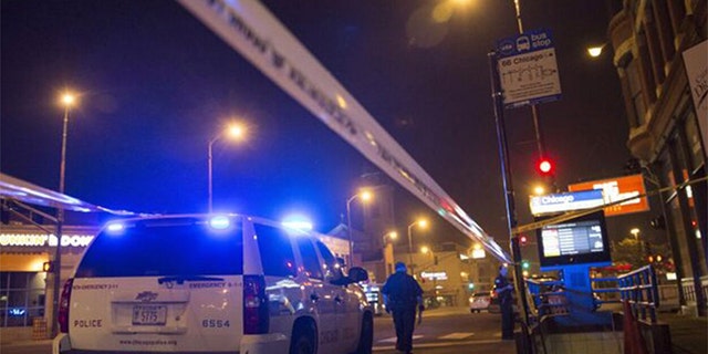 Chicago police officers investigate a crime scene of a gunshot victim. The police department reported 25 people shot and four killed during a day of gun violence across the city on Monday. ( REUTERS/Jim Young)