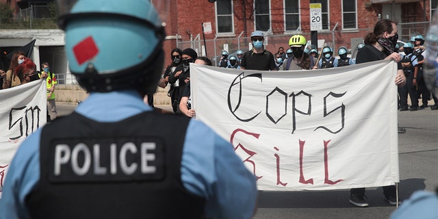 Police stand guard as pro and anti-police demonstrators gather outside of the Homan Square police station on August 15, 2020 in Chicago, Illinois.