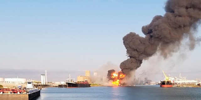 In this photo released by the U.S. Coast Guard, Coast Guard crews respond to a dredge on fire in the Port of Corpus Christi Ship Channel, Aug. 21, in Corpus Christi, Texas. Authorities say several people have been hospitalized after an explosion at the Texas port when a dredging vessel hit a natural gas pipeline in the water. (U.S. Coast Guard via AP)