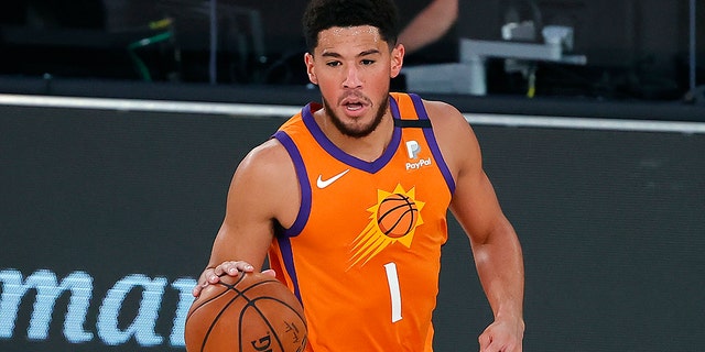 The Phoenix Suns' Devin Booker dribbles down court against the Indiana Pacers during the first half of an NBA basketball game Thursday, Aug. 6, 2020, in Lake Buena Vista, Fla. (Kevin C. Cox/Pool Photo via AP)