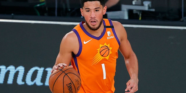 The Phoenix Suns' Devin Booker dribbles down court against the Indiana Pacers during the first half of an NBA basketball game Thursday, Aug. 6, 2020, in Lake Buena Vista, Fla. (Kevin C. Cox/Pool Photo via AP)