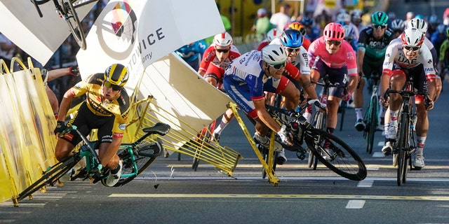 Dutch cyclist Dylan Groenewegen crashes to the ground as a bicycle is flying overhead in a major collision on the final stretch of the opening stage of the Tour de Pologne race in Katowice, Poland, Wednesday, Aug. 5, 2020. (AP Photo/Tomasz Markowski)<br>