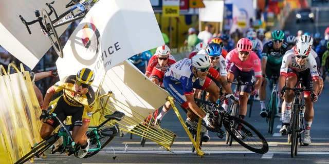 Dutch cyclist Dylan Groenewegen crashes to the ground as a bicycle is flying overhead in a major collision on the final stretch of the opening stage of the Tour de Pologne race in Katowice, Poland, Wednesday, Aug. 5, 2020. (AP Photo/Tomasz Markowski)<br>