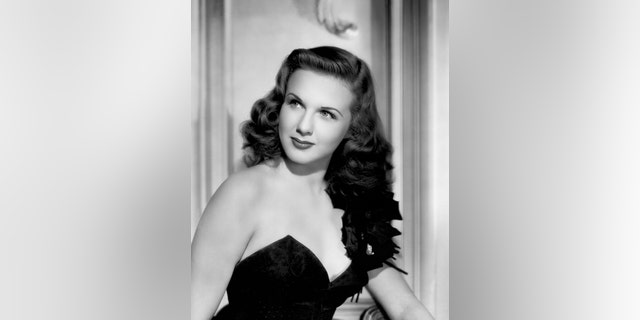 Canadian actress and singer Deanna Durbin (1921-2013) wearing a black sleeveless dress in a publicity shot once used for the cover of the magazine Yank, The Army Weekly, 1944, United States.