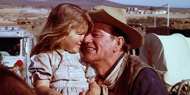 John Wayne hugs his daughter, Aissa, on the set of 'The Alamo.'