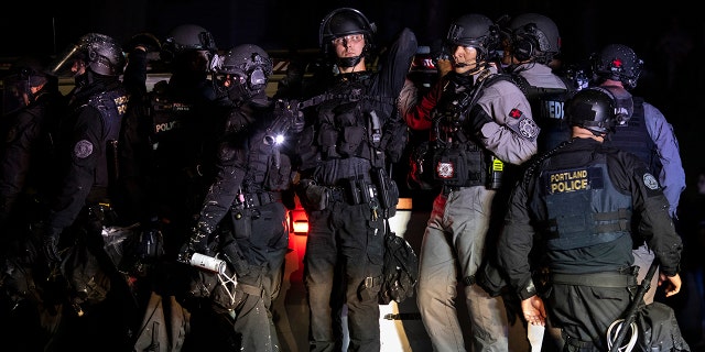 Portland police are seen in riot gear during a standoff with protesters in Portland, Oregon on August 16, 2020. (Photo by Paula Bronstein/Getty Images )