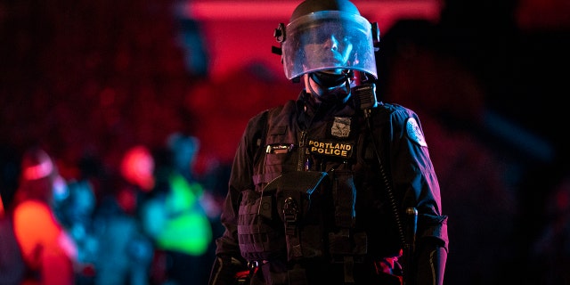 Portland police are seen in riot gear during a standoff with protesters in Portland, Oregon on August 16, 2020. Protests have continued for the 80th consecutive night in Portland since the killing of George Floyd. (Photo by Paula Bronstein/Getty Images)