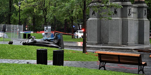 A statue of the first Canadian Prime Minister John A. Macdonald lies on the ground, with the statue's head a few meters away, at Canada Park in central Montreal on August 29, 2020, after it was pulled down by anti-racism protesters during a demonstration calling for the defunding of the police. - Macdonald's government has been accused of seeking to assimilate indigenous peoples through forcible enrollment in residential schools, for example, that led to a loss of language and culture -- described in a 2015 reconciliation commission report as "cultural genocide." (Photo by Eric THOMAS / AFP) (Photo by ERIC THOMAS/AFP via Getty Images)