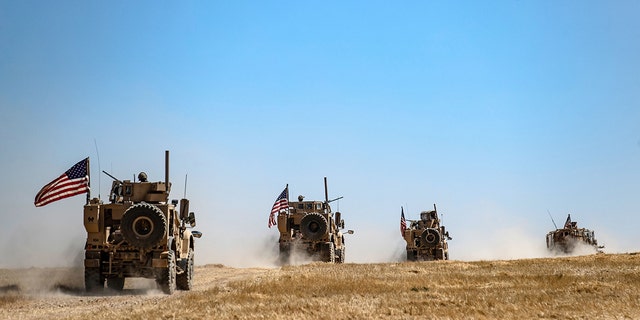 FILE - A U.S. military convoy takes part in joint patrol with Turkish troops in the Syrian village of al-Hashisha on the outskirts of Tal Abyad town along the border with Turkish troops, on Sept. 8, 2019. 
