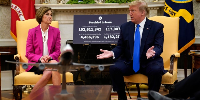 In this May 6, 2020 file photo, President Donald Trump speaks during a meeting with Gov. Kim Reynolds, R-Iowa, in the Oval Office. An aggressive push by Iowa's staunchly pro-Trump governor to reopen schools amid the state's worsening coronavirus outbreak has descended into chaos, with some districts and teachers rebelling and experts questioning the data metrics.