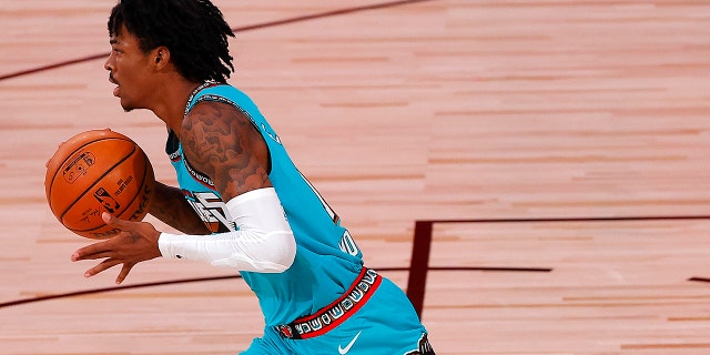 Ja Morant of the Memphis Grizzlies dribbles down court during the first half of an NBA basketball game Sunday, Aug. 9, 2020, in Lake Buena Vista, Fla. (Kevin C. Cox/Pool Photo via AP)
