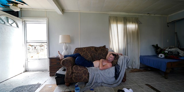 James Townley, who has a heart condition, lies on his couch with no electricity in his partially destroyed mobile home in Lake Charles, La., in the aftermath of Hurricane Laura, Sunday, Aug. 30, 2020.