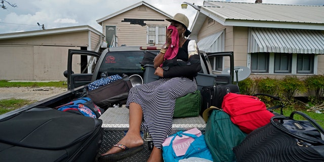 Rakisha Murray cries in relief as she arrives to see her mother's home largely undamaged, after she returned from evacuation with her mother and other family in Lake Charles, La., in the aftermath of Hurricane Laura, Sunday, Aug. 30, 2020.