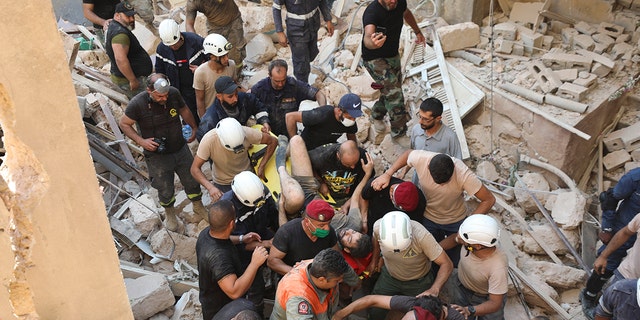 A survivor is taken out of the rubble after a massive explosion in Beirut, Lebanon, Wednesday, Aug. 5, 2020. (AP Photo/Hassan Ammar)