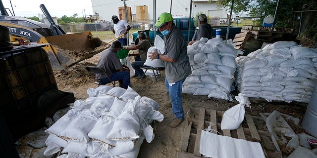 Municipal workers fill sandbags for the elderly and those with disabilities ahead of Hurricane Laura in Crowley, La., Tuesday. (AP Photo/Gerald Herbert)