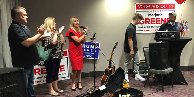 Construction executive Marjorie Taylor Greene, third from left, claps with her supporters at a watch party event, late Tuesday, Aug. 11, 2020, in Rome, Ga. Greene won the GOP nomination for northwest Georgia's 14th Congressional District. (AP Photo/Mike Stewart)