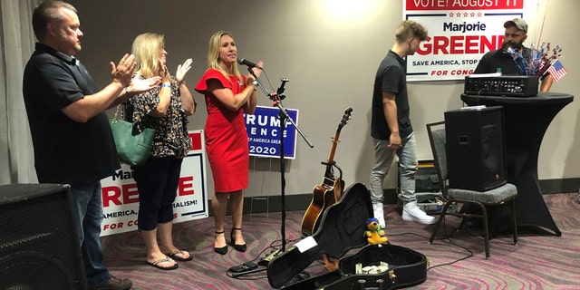 Construction executive Marjorie Taylor Greene, third from left, claps with her supporters at a watch party event, late Tuesday, Aug. 11, 2020, in Rome, Ga. Greene won the GOP nomination for northwest Georgia's 14th Congressional District. (AP Photo/Mike Stewart)
