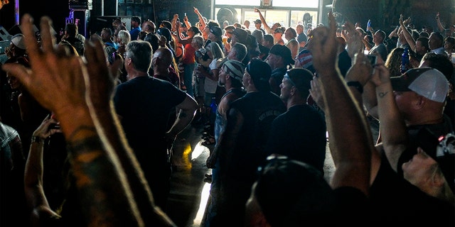 People cheer during a concert at the Full Throttle Saloon during the 80th Annual Sturgis Motorcycle Rally on August 7, 2020 in Sturgis, South Dakota. While the rally usually attracts around 500,000 people, officials estimate that more than 250,000 people may still show up to this year's festival despite the coronavirus pandemic.