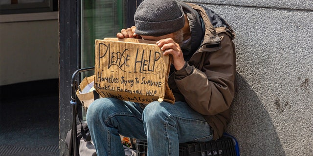 Homeless man holding a cardboard sign, asking for help in downtown, Manhattan, New York City, on May 2, 2019. 
