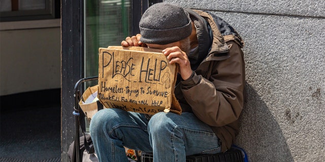 Homeless man holding a cardboard sign, asking for help in downtown, Manhattan, New York City, on May 2, 2019.