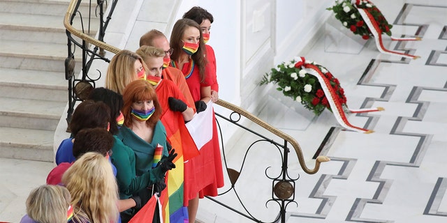 Members of parliament wearing rainbow-themed masks, representing the LGBT symbol, pose for a picture after the swearing-in ceremony of Andrzej Duda as Polish President in Warsaw, Poland August 6, 2020. 