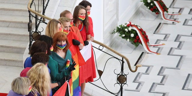 Members of parliament wearing rainbow-themed masks, representing the LGBT symbol, pose for a picture after the swearing-in ceremony of Andrzej Duda as Polish President in Warsaw, Poland August 6, 2020.