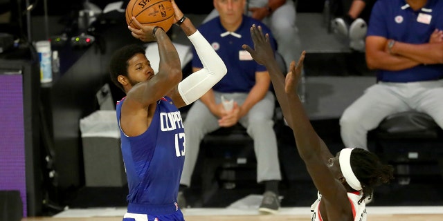 Los Angeles Clippers guard Paul George (13) shoots over Portland Trail Blazers forward Wenyen Gabriel (35) during the first half of an NBA basketball game Saturday, Aug. 8, 2020, in Lake Buena Vista, Fla. (Kim Klement/Pool Photo via AP)