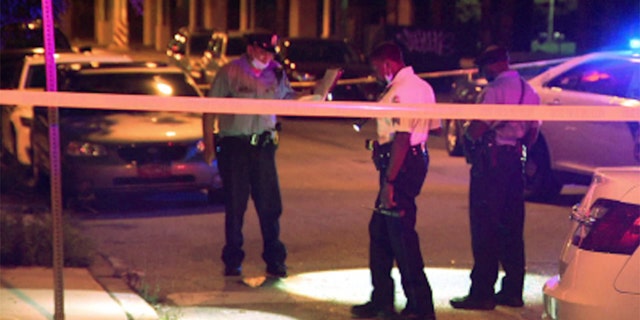 Police work the scene where five people were shot as they were attending a large block party in Philadelphia.