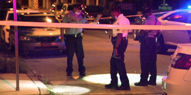 Police work the scene where five people were shot as they were attending a large block party in Philadelphia.