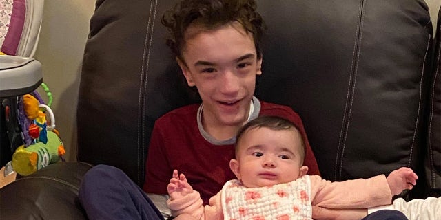 Nicky, 7, with his 11-month-old sister, Sophia, who was baptized Saturday, Aug. 8, 2020.