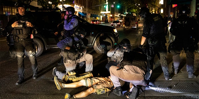 A man is treated after being shot Saturday, Aug. 29, 2020, in Portland, Ore. He later succumbed to his injuries. (AP Photo/Paula Bronstein)