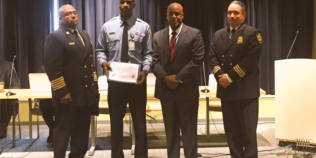 Detroit Firefighter Sivad Johnson holds plaque given to him in 2016 for saving the life of an unconscious man.