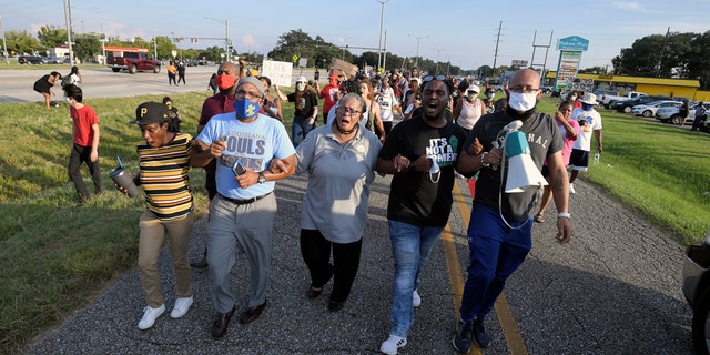 Marja Broussard, center, president of the Lafayette chapter of the NAACP, walking down Evangline Thruway with others demanding justice for Trayford Pellerin on Saturday in Lafayette, La.