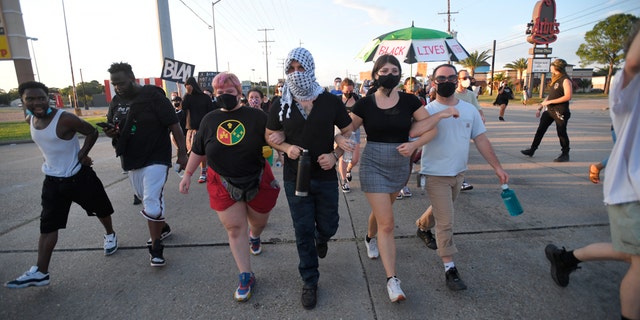 Protesters march down demanding justice for Trayford Pellerin on Saturday in Lafayette, La.