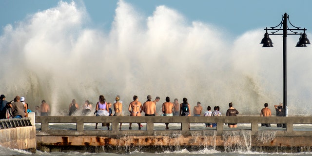 Curious residents of Key West, Fla., flock to the Edward B. Knight Pier Monday to witness the wind and wave action of Tropical Storm Laura as it passes well to the west of the Florida Keys.