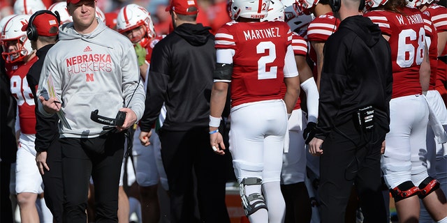 Head coach Scott Frost of the Nebraska Cornhuskers greets quarterback Adrian Martinez #2 after a series of plays against the Wisconsin Badgers at Memorial Stadium on November 16, 2019 in Lincoln, Nebraska.